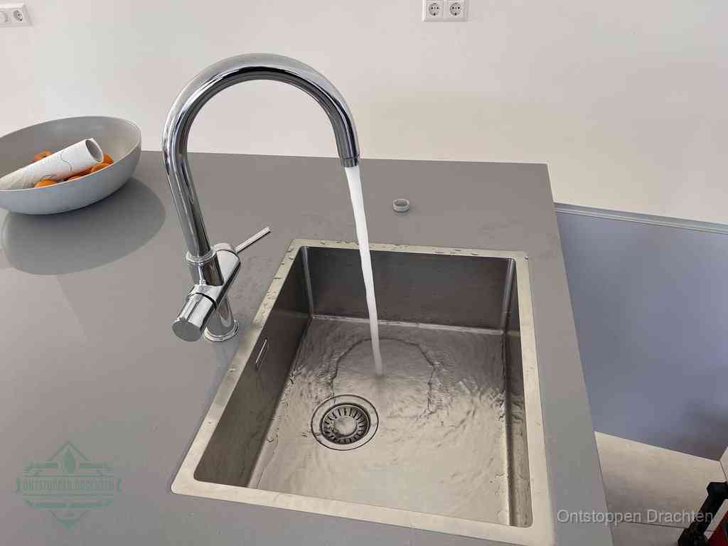 Een vrij doorstromende rvs spoelbak waar het water moeiteloos wegloopt, het resultaat van slim onderhoud dat geld bespaart in Drachten