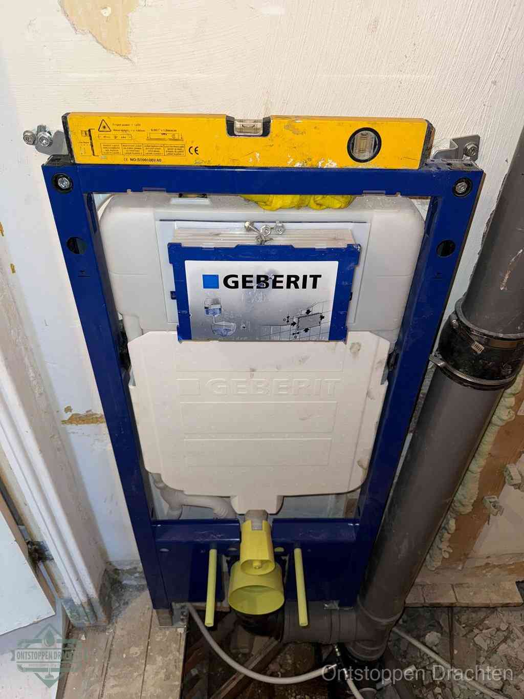 Een Geberit inbouwreservoir met frame voor een hangtoilet tegen de wand, met de afvoerbocht naar de vloer, kenmerkend voor een verstopt hangtoilet in Drachten