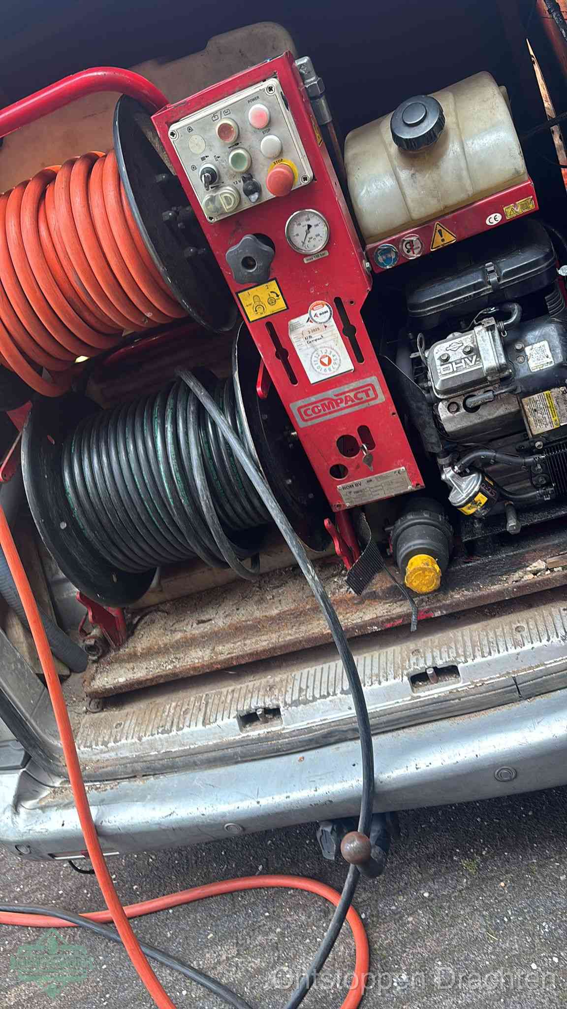 Een rood hogedruk-rioolreinigingstoestel in de laadbak van de bedrijfsbus, apparatuur voor een hardnekkige afvoerverstopping in Drachten