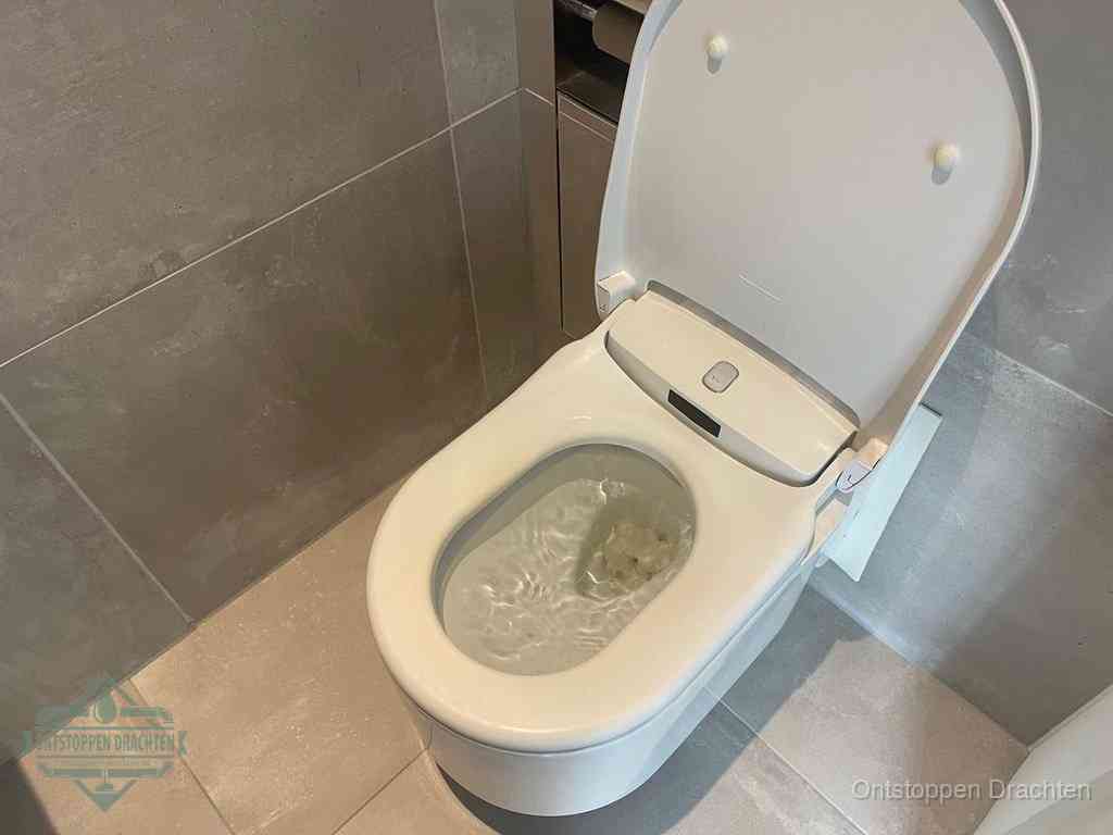 Een toiletpot vol troebel water met drijvend papier en restanten, de meest voorkomende oorzaak van een verstopte wc in Drachten
