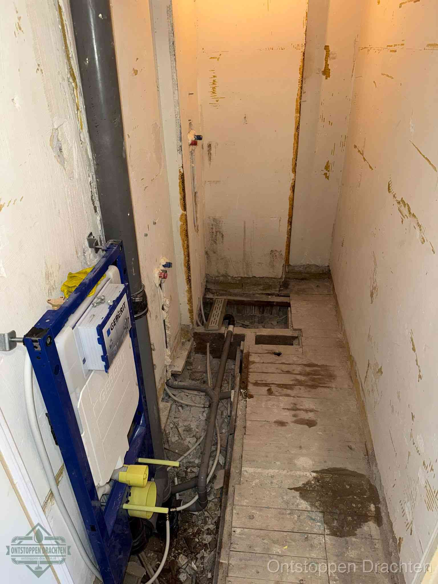 Een opgebroken toiletruimte tijdens renovatie met een Geberit inbouwreservoir en blootliggende oude afvoerleidingen, typisch voor oudere woningen in Drachten